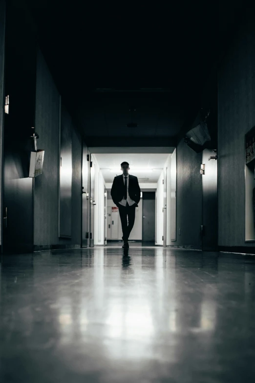 a man walks down the hallway of an office building