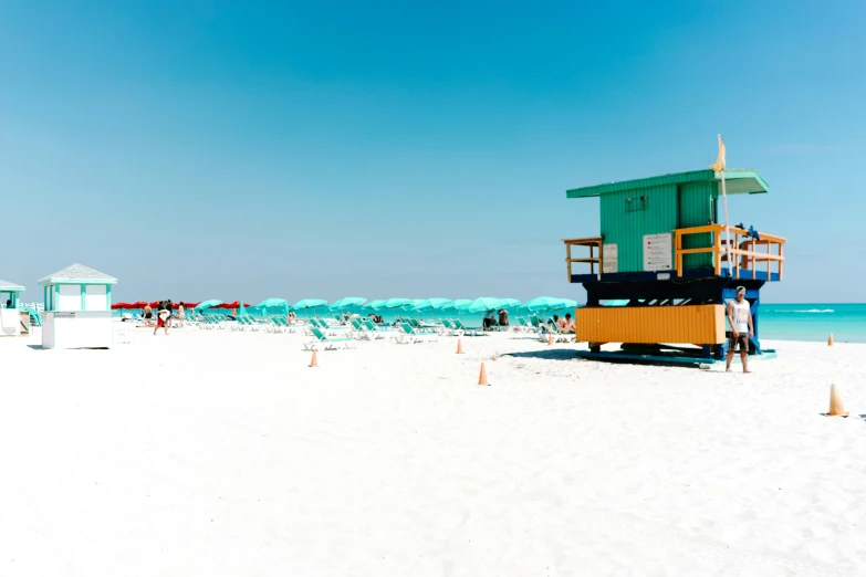 several beach umbrellas line the white sand of a beach