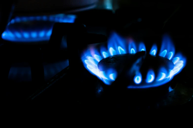 a gas stove is blue with glowing flames