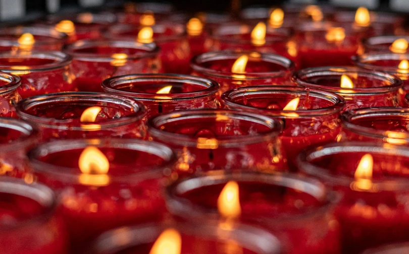 many glasses of red candles are shown in a row