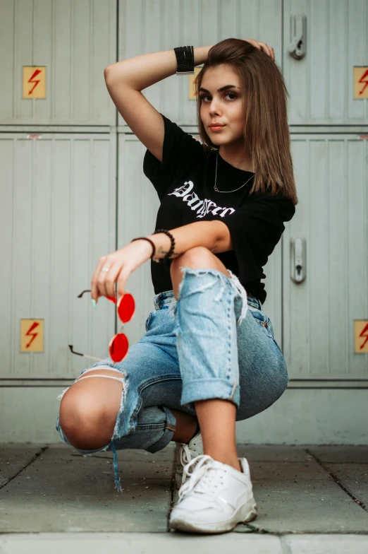 a girl sitting in front of a garage door with her arm behind her head