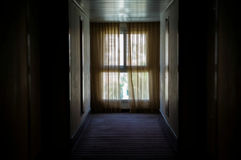 the hallway of a house with a curtain open