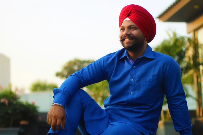 a man wearing a blue shirt and red turban