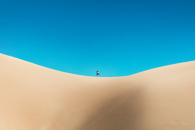 a lone person stands in the middle of a big desert