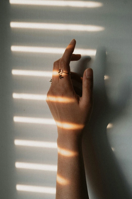 someone's hand reaching up towards their shadow on a wall