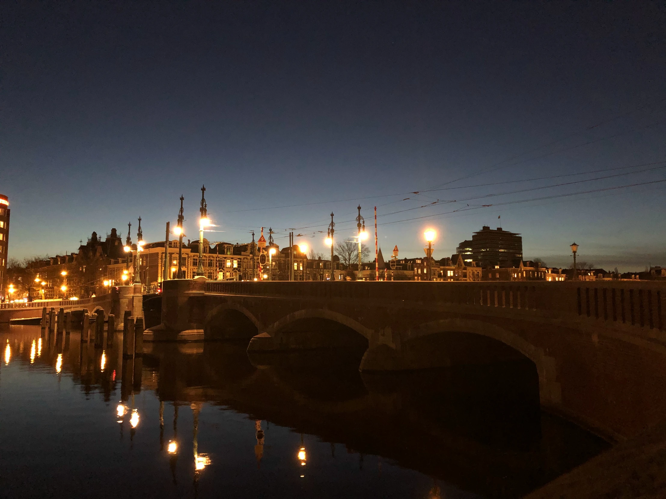 the bridge is at night with a city in the distance