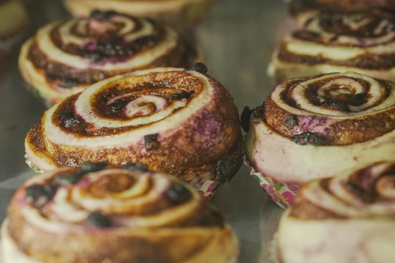 a tray of pastry is displayed with blueberries in the middle