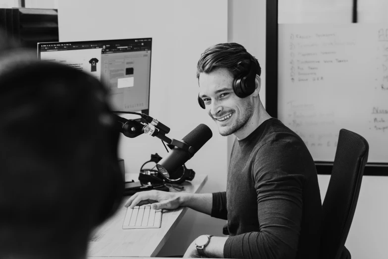 black and white po of a person with a microphone talking into a microphone