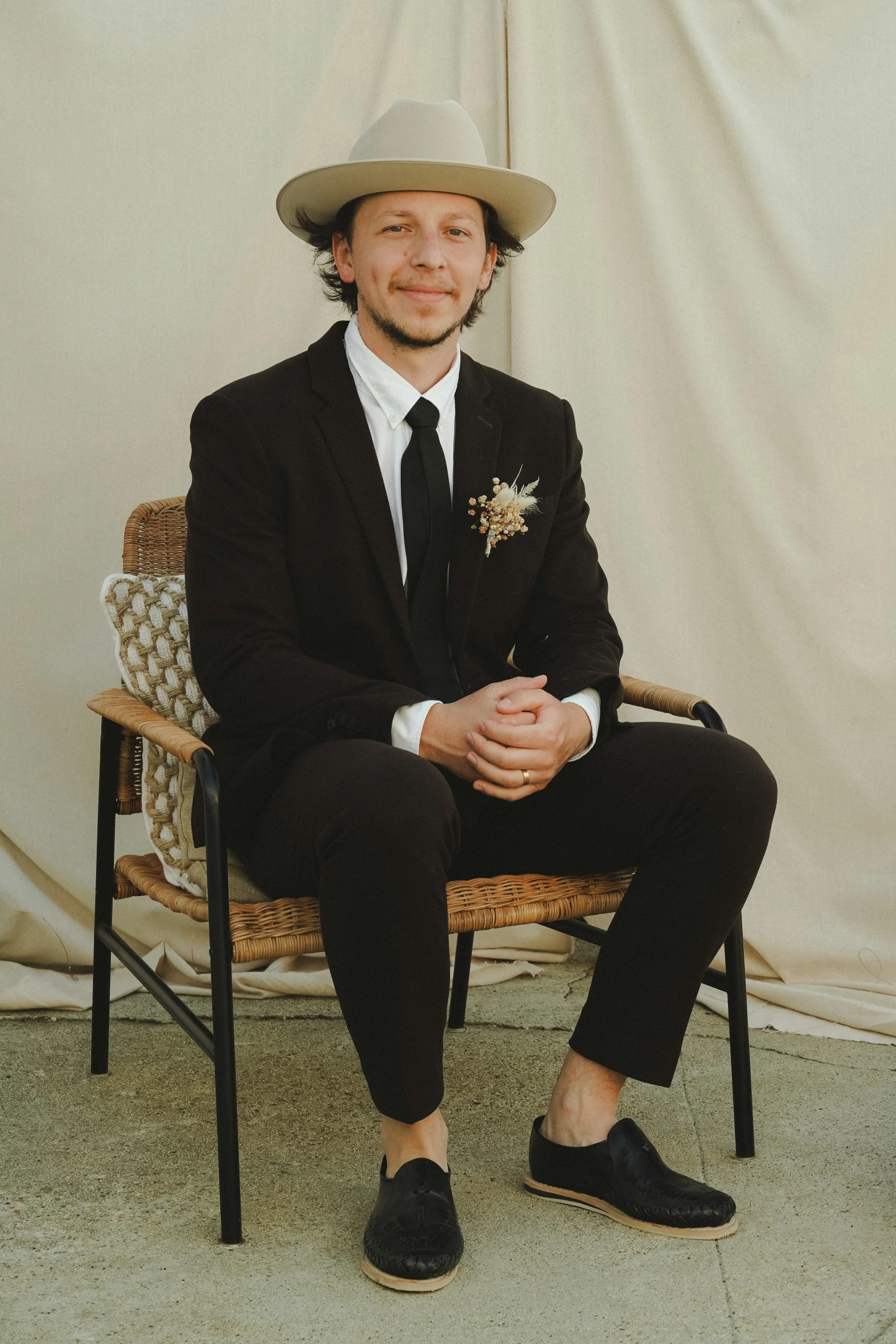 a man wearing a cowboy hat sitting in a chair