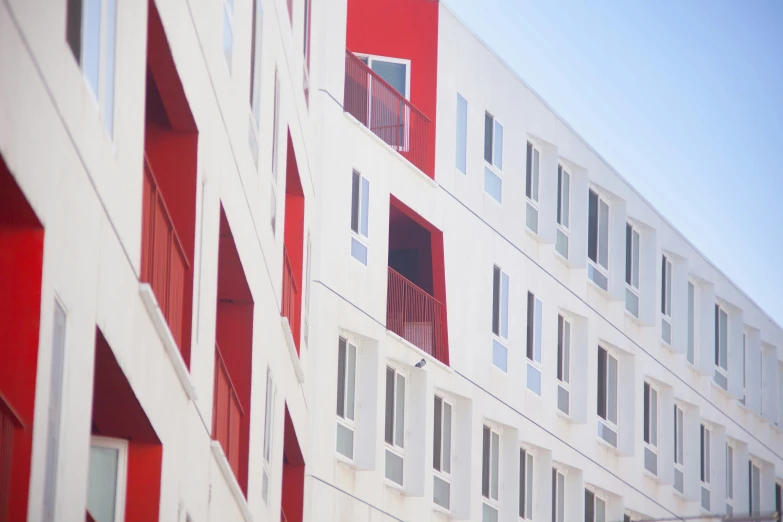 red and white apartment building with windows and bars