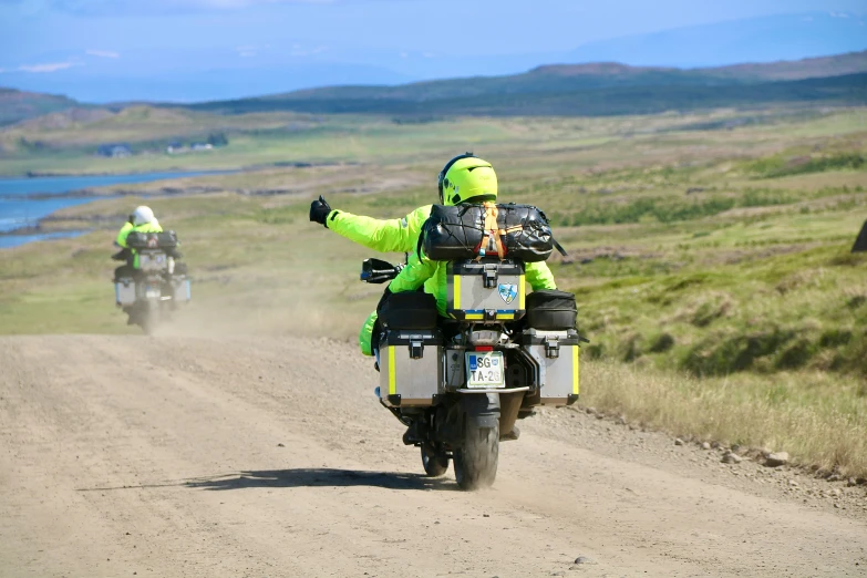 a man riding a motorcycle on a dirt road