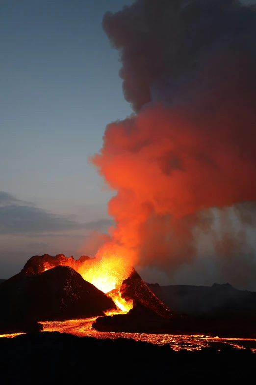 a lava volcano is lit up by orange flames and steam