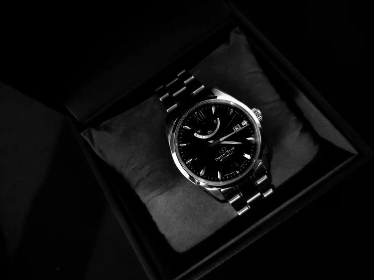 a watch is in a black box on a dark background