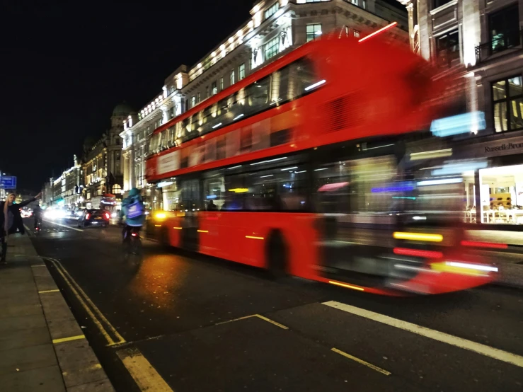 a double decked bus rides on the street