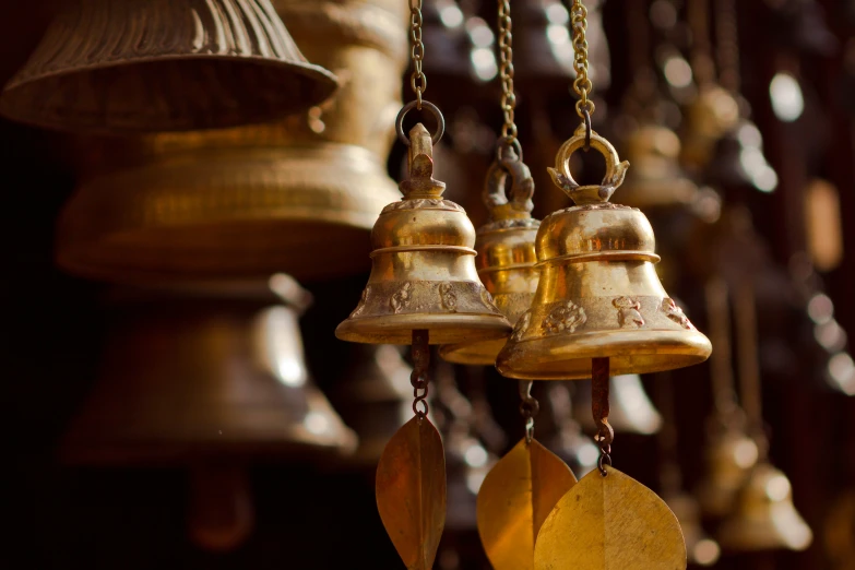 three bells in gold and silver hanging from the ceiling