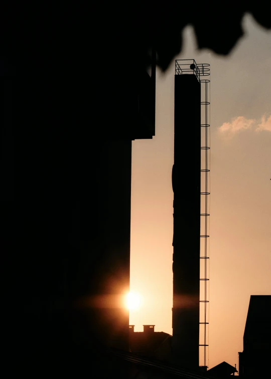 a building that has a tall tower in front of the sun