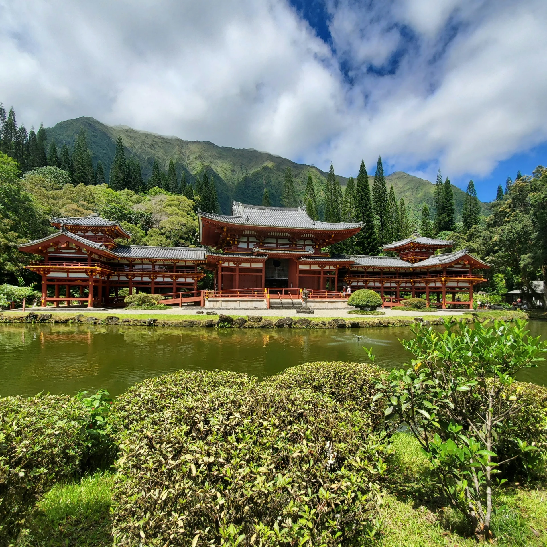 a large building in a green valley surrounded by forest