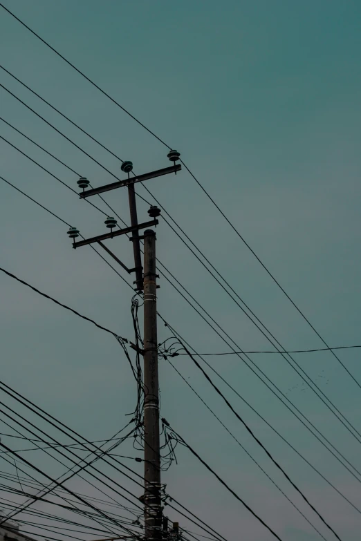 telephone wires and telephone poles against a blue sky