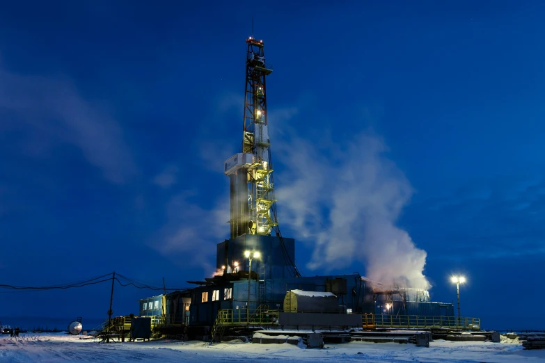 a snow covered landscape with many lights on a well lit building