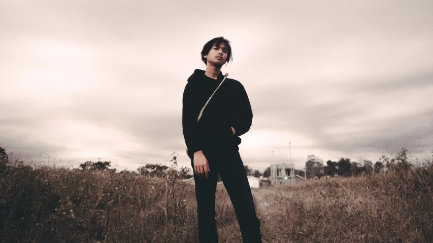 the man is posing in a field with an umbrella