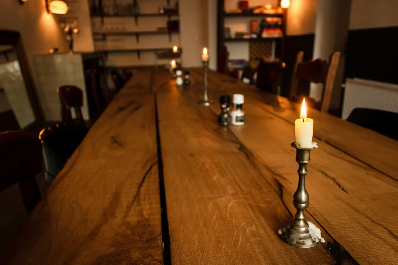 the long wooden table with three lit candles