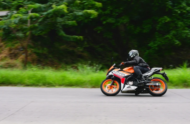 a person riding on the back of a motorcycle down a road