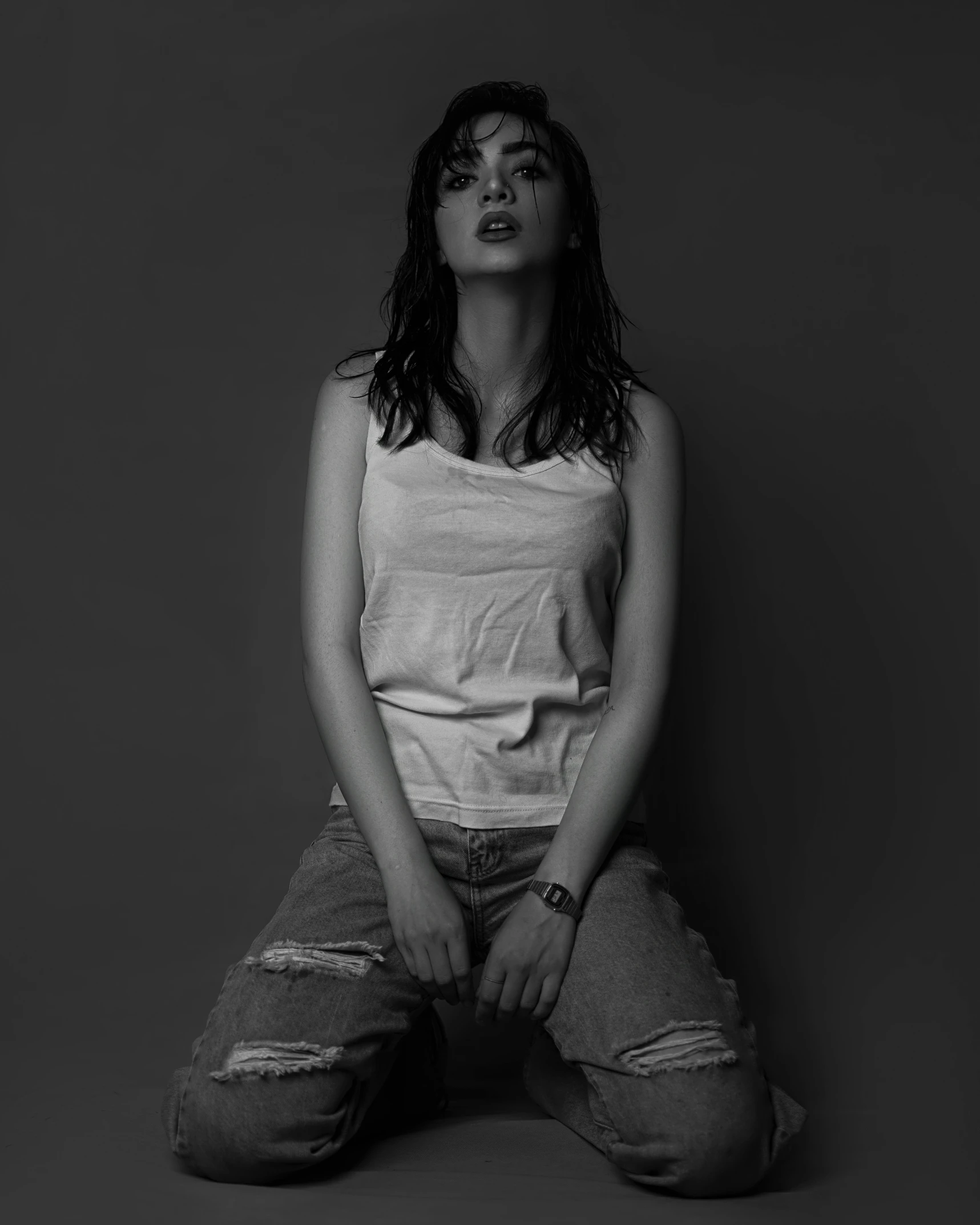 woman sitting cross - legged against a dark background