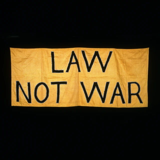 a yellow sign reading law not war on a black background