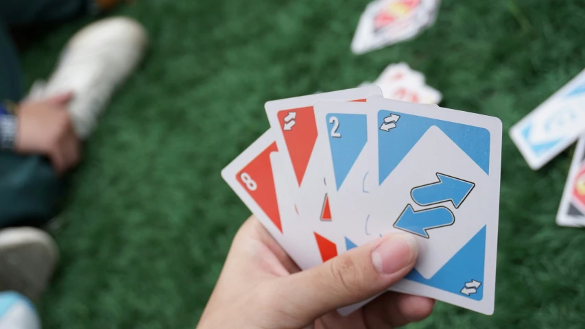 three matching cards on a lawn with a person sitting in the background