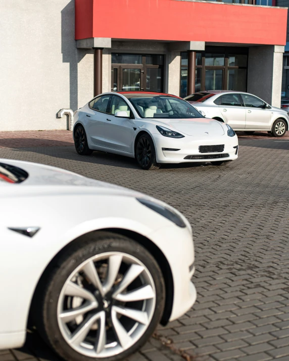 two cars are parked in front of a small, brick parking lot