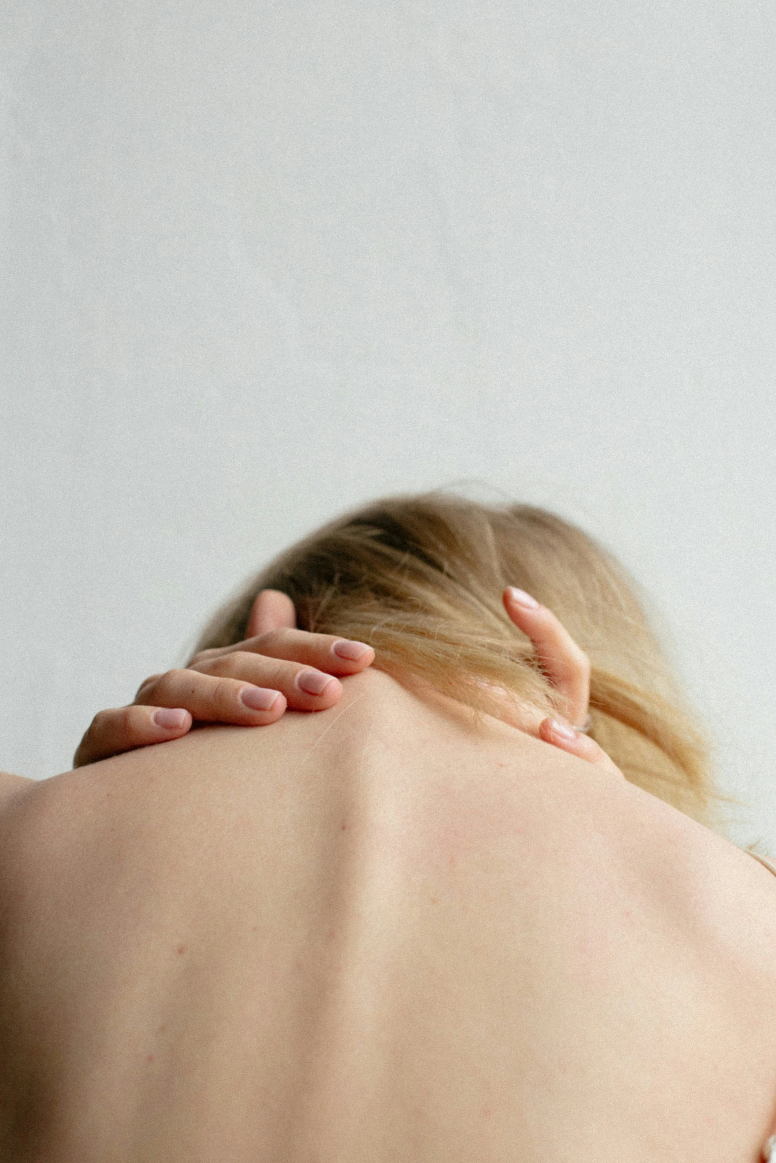 a person holding their back and rubbing his head in front of the camera