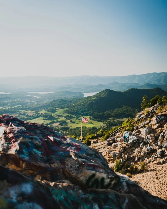 a colorful rock sitting on the side of a cliff