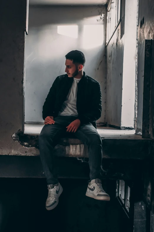 a man in a jacket sitting in an empty room