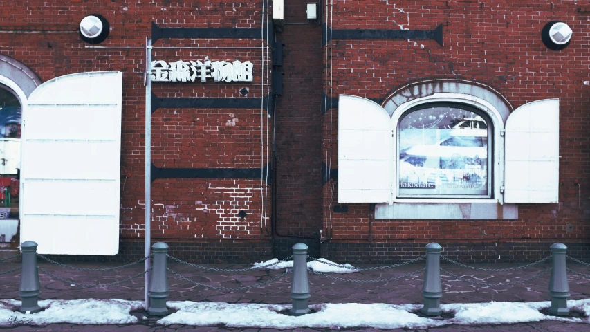 street signs and barriers are in front of a red brick building