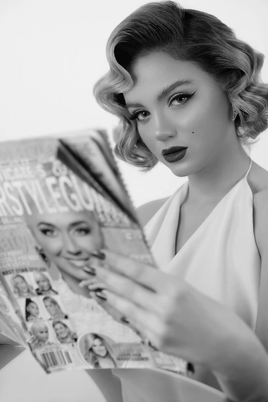 a woman in a white gown reading a newspaper