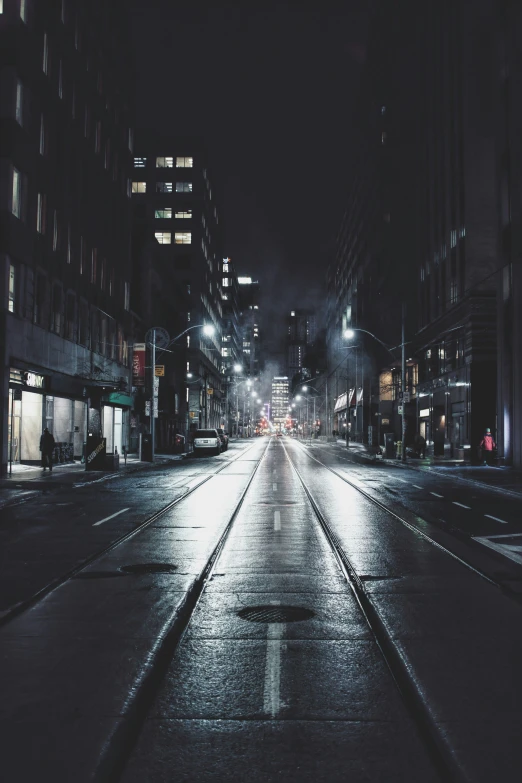a night time view of an empty street in the city