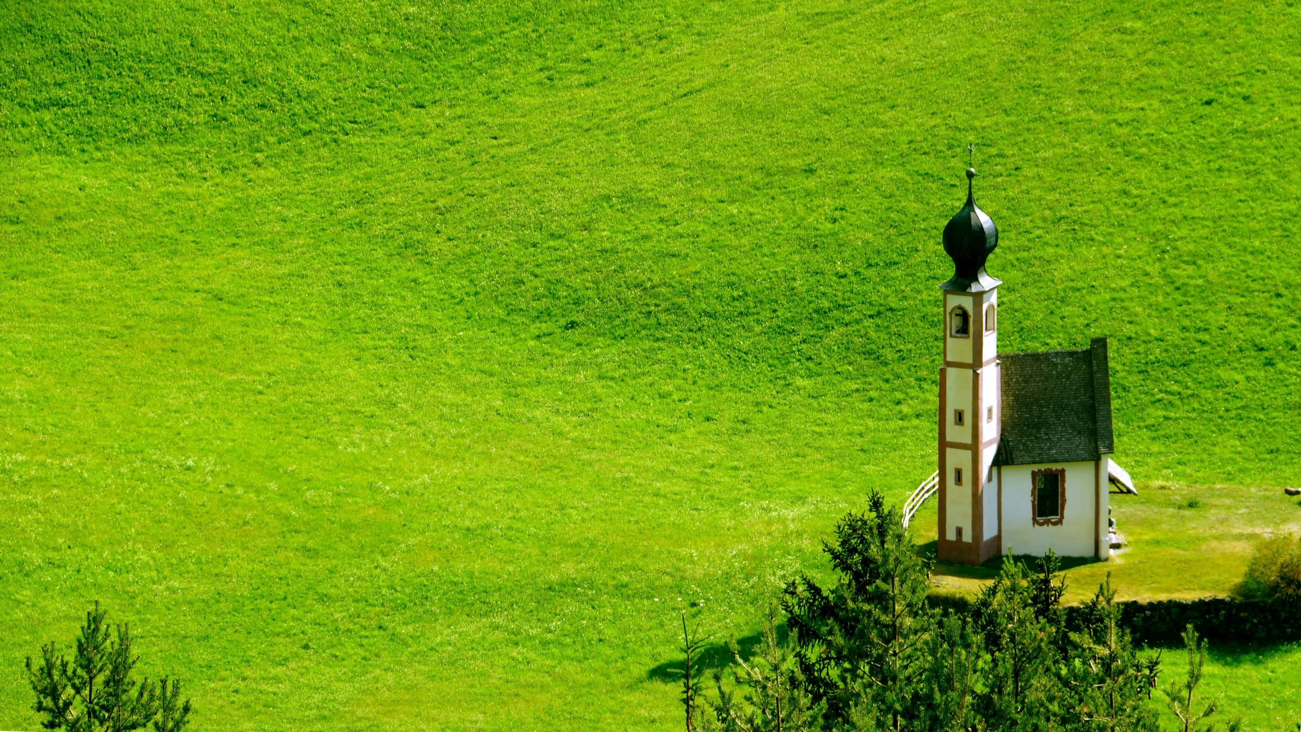 a green field has a small white building