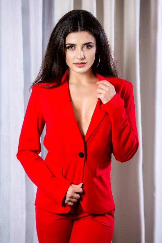 a woman is wearing a red suit and posing for the camera