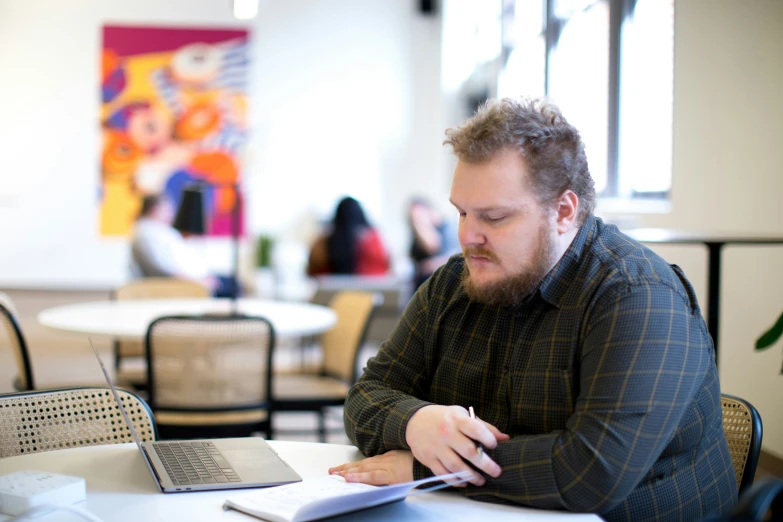 man sitting at a table with a notebook and a keyboard