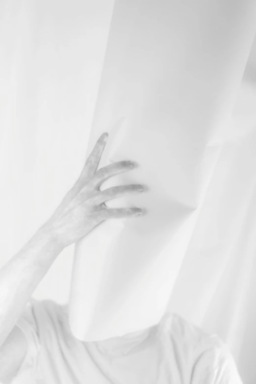 a person covering their face with a white sheet