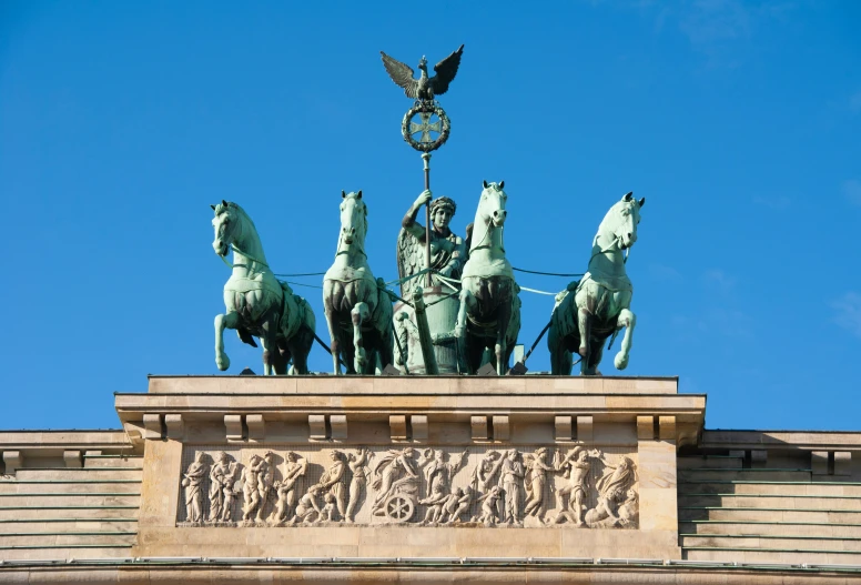 three statues of horses atop a building