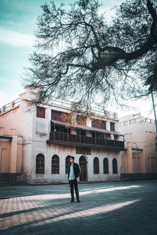 a man walking down a sidewalk next to a tall building