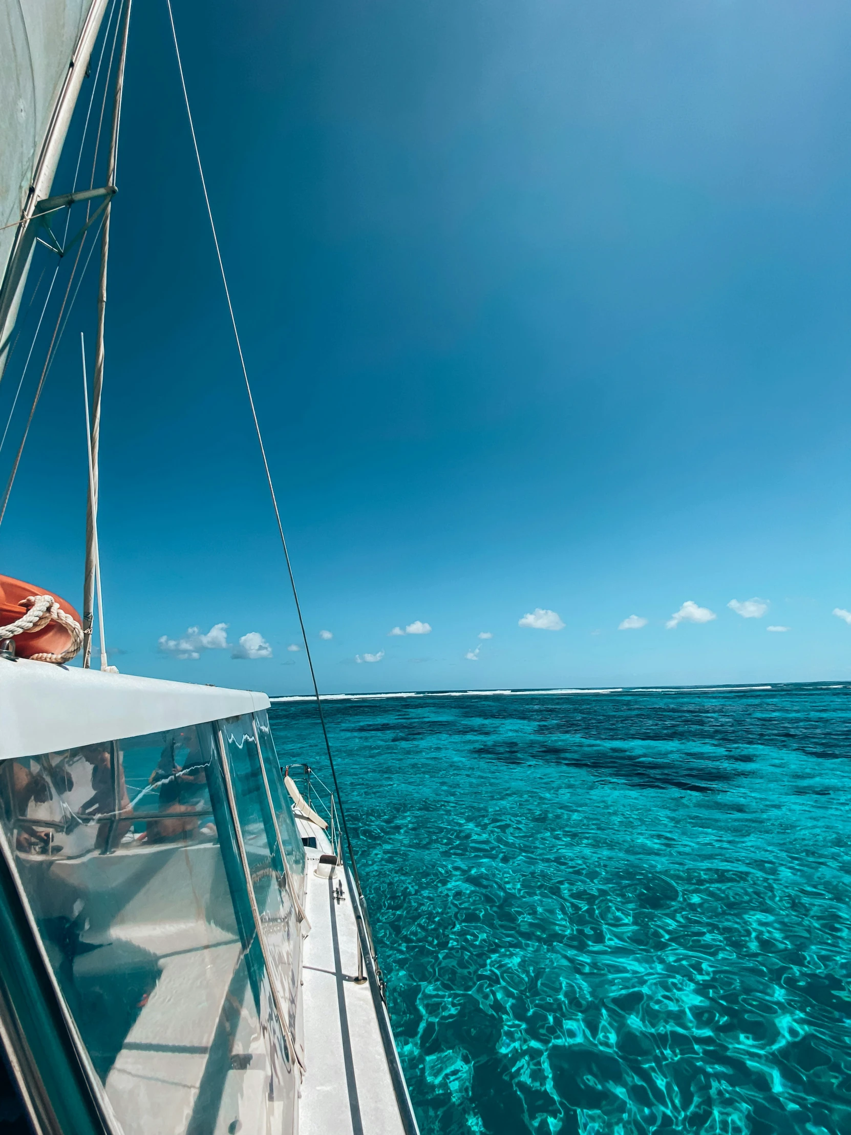 a sail boat in the middle of clear water