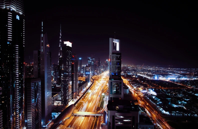 street in city with cars driving on it at night