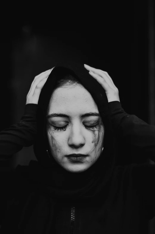 a woman standing with her hands to her face