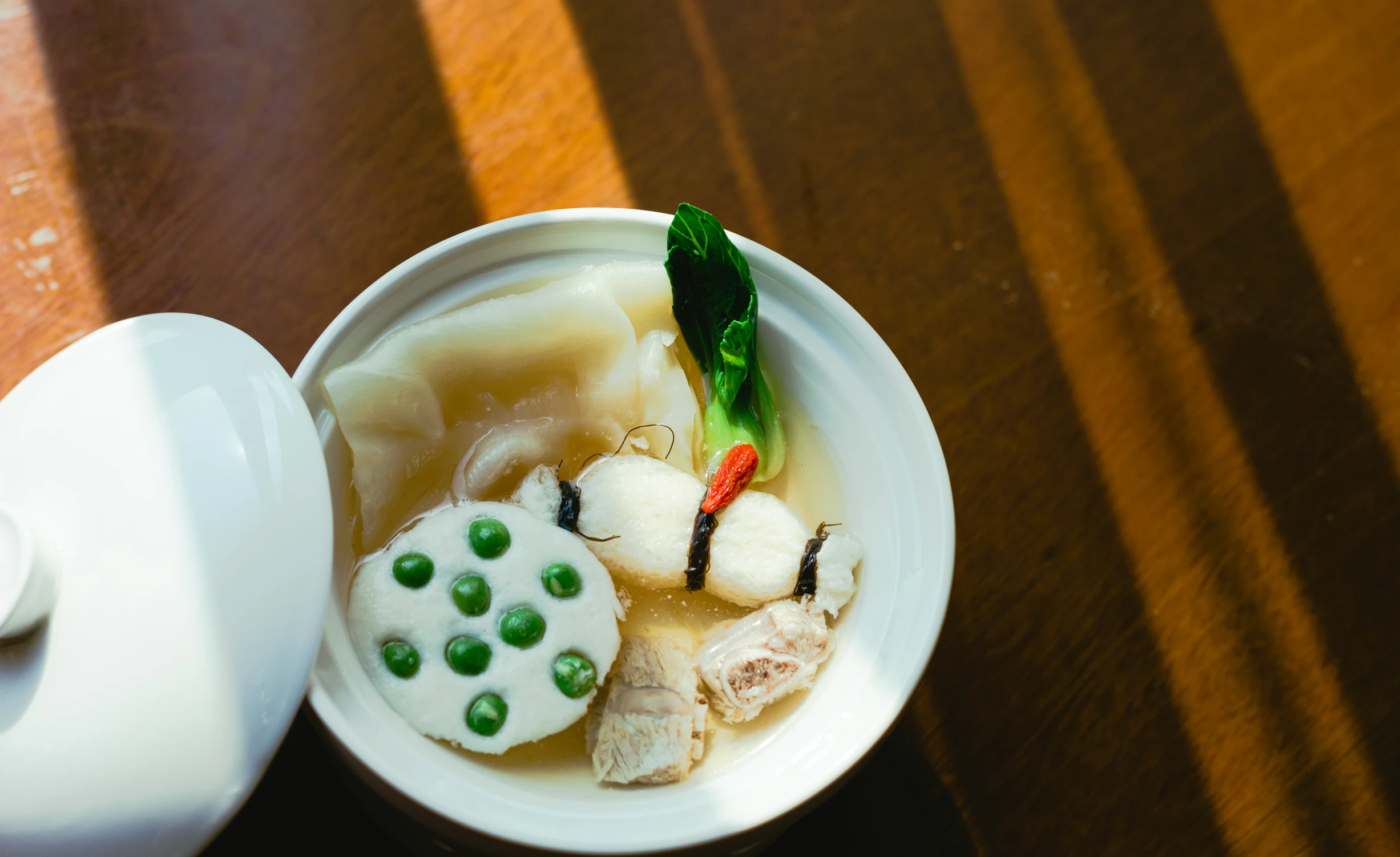 there is soup with broth and dumplings in a small bowl