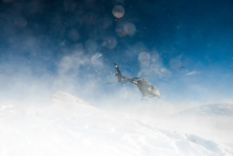 a man in the snow is flying near a helicopter