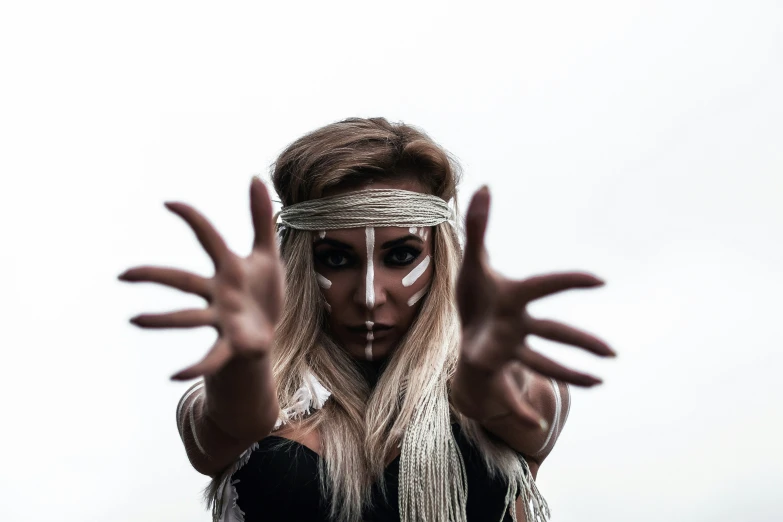 a woman in white makeup holding out her hands