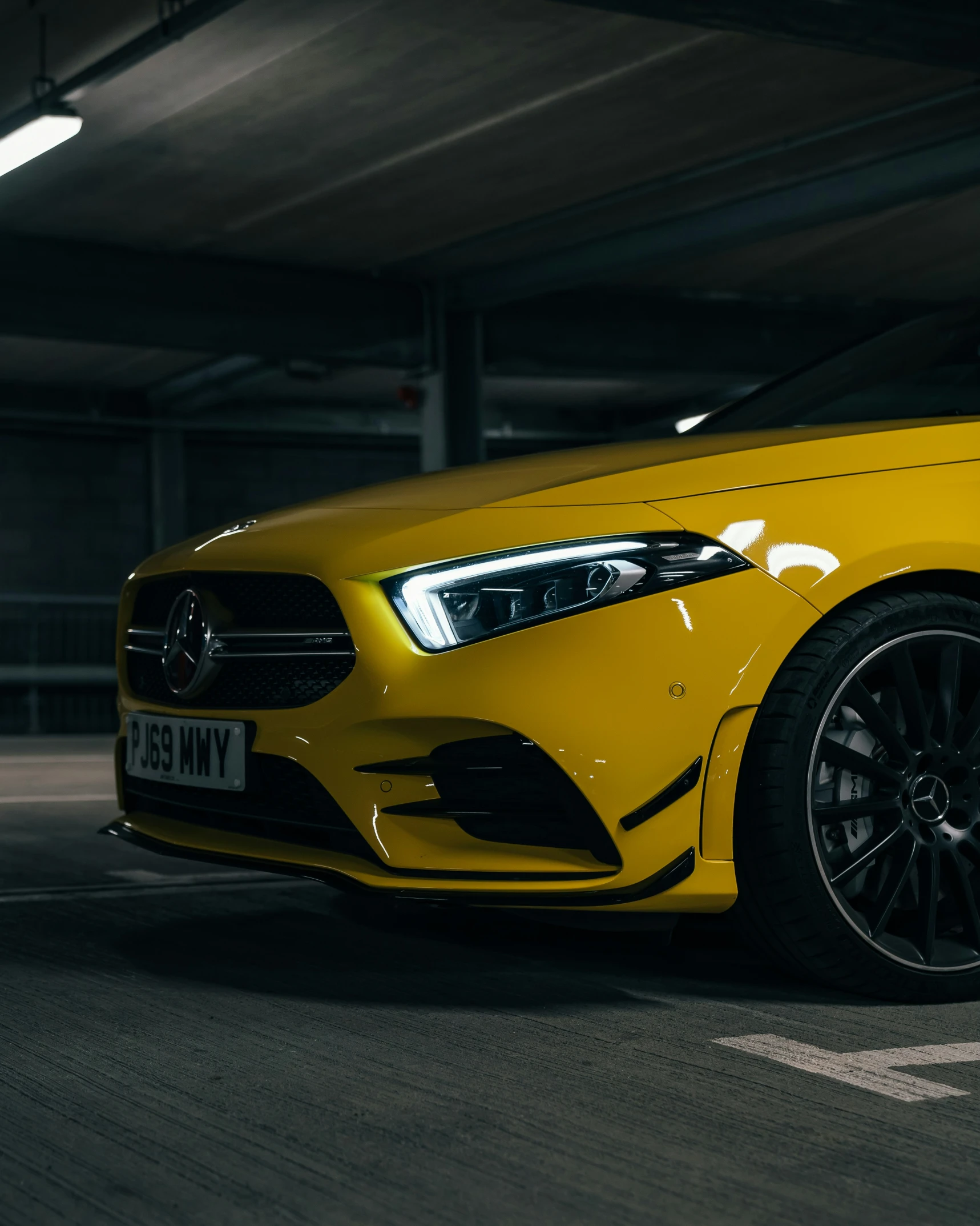 a yellow mercedes benz vehicle in a garage