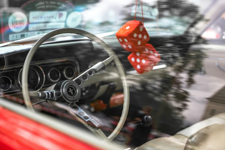 a red car with a red dice hanging on the steering wheel